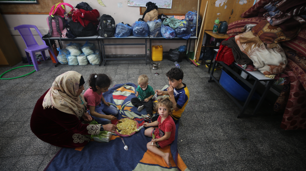 Αναζητώντας καταφύγιο, μια μητέρα ταΐζει τα παιδιά της στη Γάζα κατά τη διάρκεια των βομβαρδισμών από την κυβέρνηση του Ισραήλ.